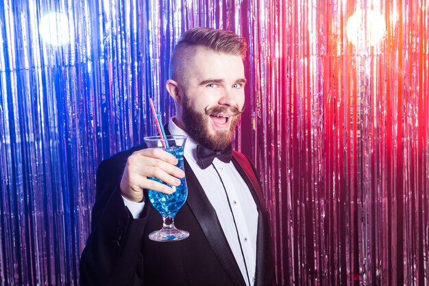 Fête du club et concept de vacances portrait d'un bel homme élégant et heureux dans un costume coûteux détient