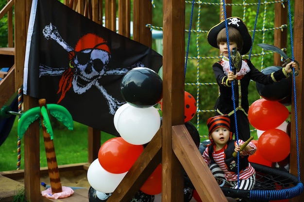 Fête d'enfants dans un style pirate. Des enfants en costumes de pirates jouent à Halloween.