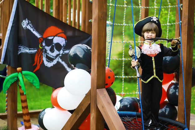 Fête d'enfants dans un style pirate Des enfants en costumes de pirates jouent à Halloween