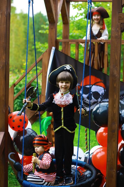 Photo fête d'enfants dans un style pirate des enfants en costumes de pirates jouent à halloween