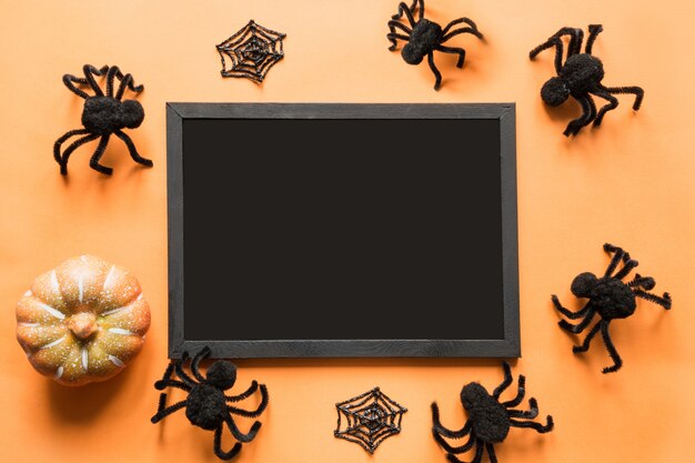 Fête d'Halloween en blanc avec décor de fête, araignées noires, web sur orange. Lay plat, vue de dessus. fond