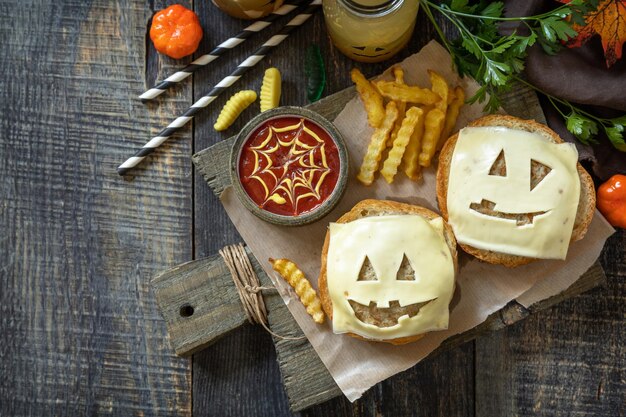 Photo fête d'halloween nourriture fête d'halloween plaisir hamburger fantôme sauce ketup et frites de pommes de terre sur une table en bois