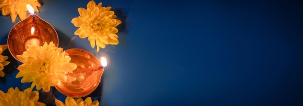 Fête indienne Diwali Lampes à huile traditionnelles diya et fleurs jaunes sur fond bleu Fête de la lumière