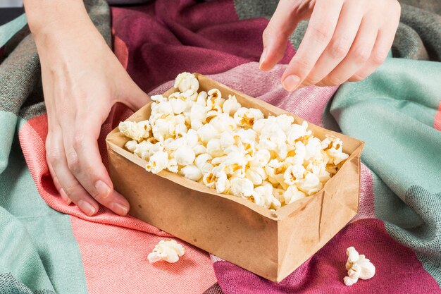 Fête de juin. Main tenant du pop-corn sur un tissu coloré.