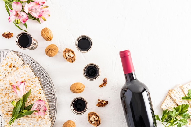 Fête juive de la Pâque fond blanc avec des verres d'argent de mise en page plate de produits festifs de vin rouge