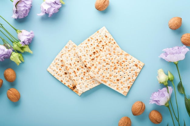 Fête juive de Pessah Concept de célébration de la Pâque Matzah vin casher rouge et noix Pain juif rituel traditionnel sur fond bleu clair Nourriture de la Pâque