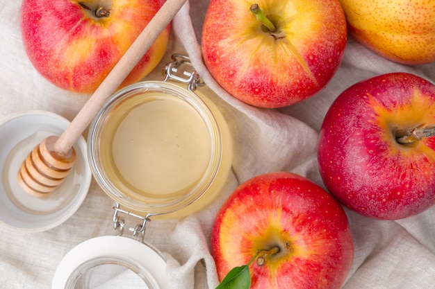 Fête juive de Rosh Hashana avec du miel et des pommes sur une table en bois.