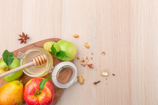 Fête juive de Rosh Hashana avec du miel et des pommes sur une table en bois.