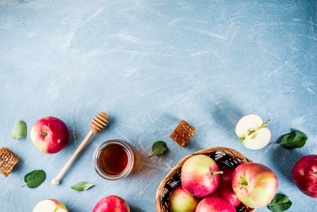 Fête juive Rosh Hashanah ou concept de fête de pomme, avec pommes rouges, feuilles de pomme et miel en pot