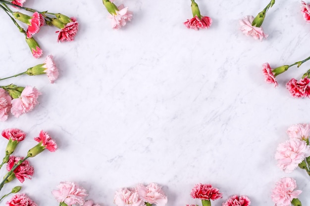 Fête des Mères Saint Valentin concept de design d'arrière-plan beau bouquet de fleurs d'oeillets rouges roses sur la vue de dessus de table en marbre espace de copie plat