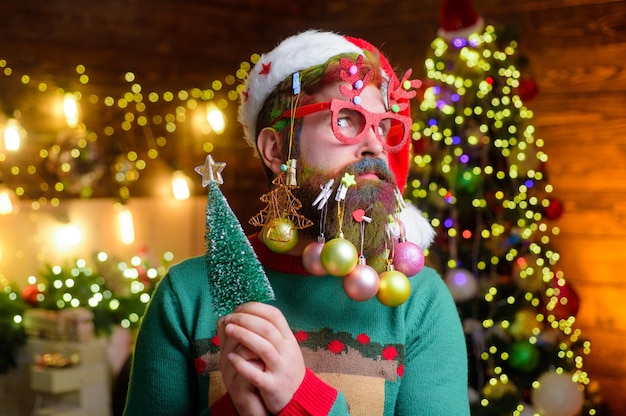 Fête de Noël ou du nouvel an vacances d'hiver mec du nouvel an en bonnet de noel avec des boules de décoration en