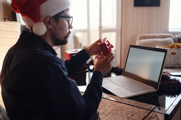 Fête de Noël virtuelle à la maison Homme souriant portant un bonnet de Noel