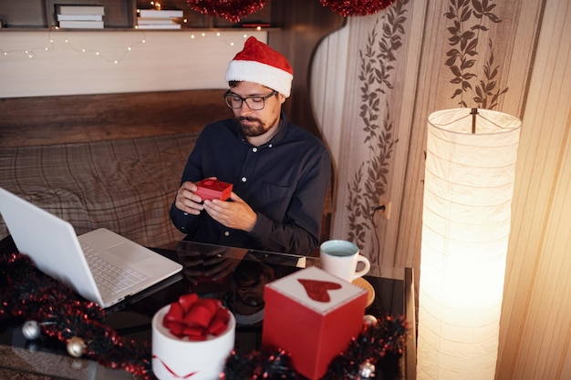 Fête de Noël virtuelle à la maison Homme souriant portant un bonnet de Noel