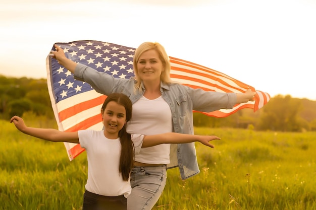 Fête patriotique. Héhé, mère et sa fille enfant fille avec drapeau américain à l'extérieur. Les États-Unis célèbrent le 4 juillet.