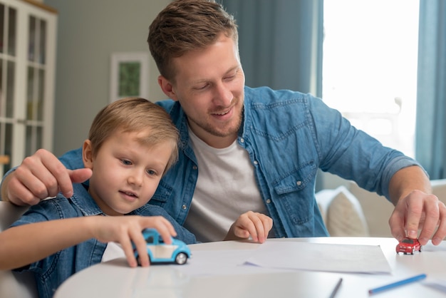 Photo fête des pères papa et fils jouant avec des jouets