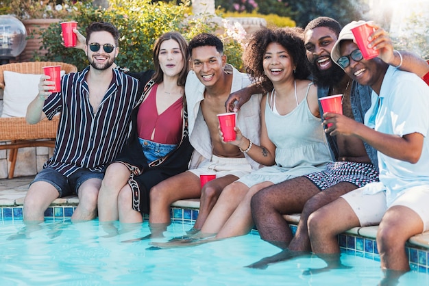 Photo fête de la piscine bière et amis rire s'amuser et faire la fête événement de célébration d'été et portrait de groupe de personnes hommes et femmes avec de l'alcool tremper les pieds dans l'eau et rire d'une blague ou d'un meme drôle