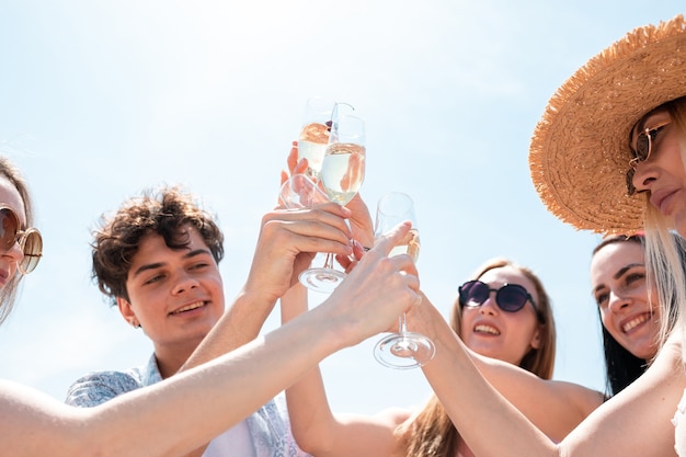 Fête saisonnière à la station balnéaire. Groupe d'amis célébrant, se reposant