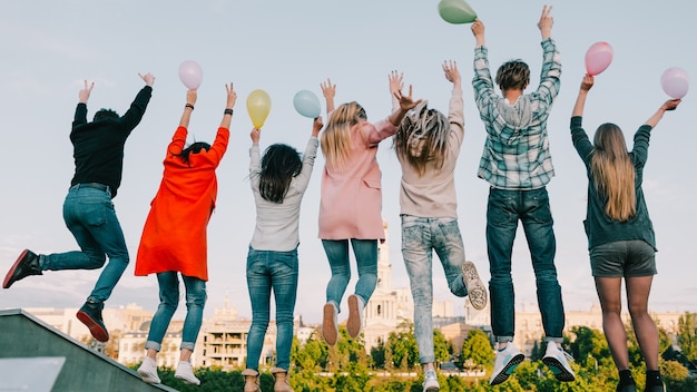 Fête sur le toit. Divertissement de bonheur de joie d'adolescent. Amis avec des ballons s'amusant à sauter.