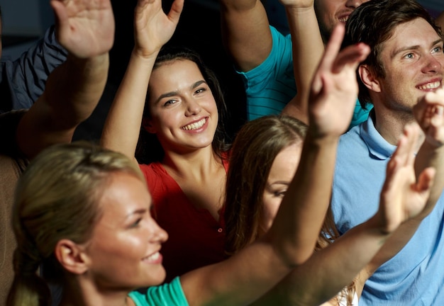 fête, vacances, célébration, vie nocturne et concept de personnes - amis souriants agitant la main au concert en club