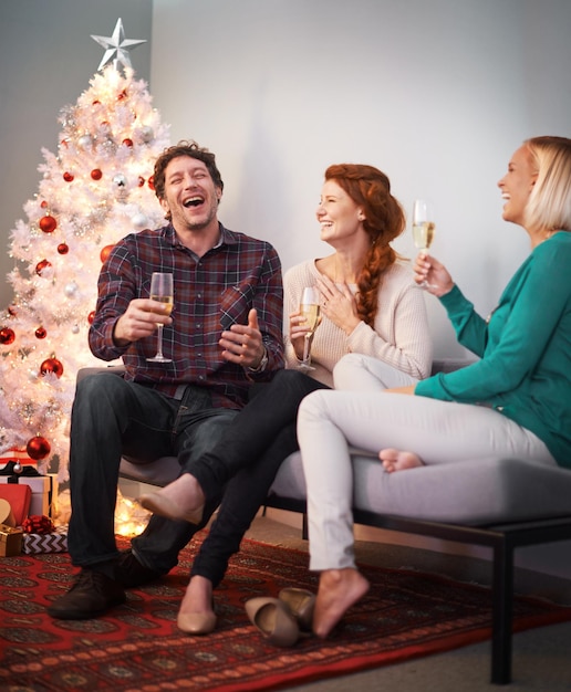 Fêtes amicales Photo de trois amis dégustant une coupe de champagne à Noël