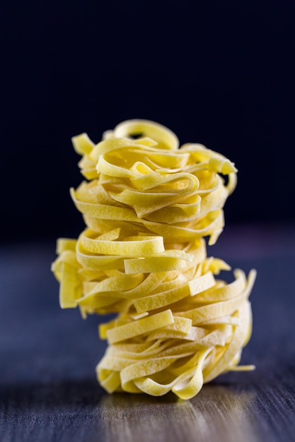 Fettuccine biologique nids de pâtes sur planche de bois.