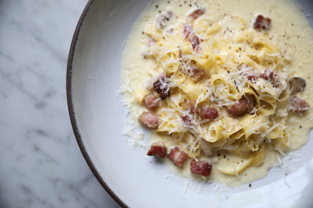 Photo fettuccine carbonara, spaghettis de pâtes fettuccine avec jambon au lard et champignons à la sauce blanche cuisine italienne