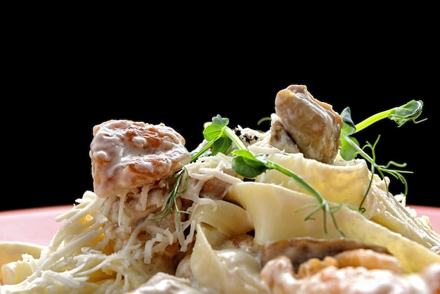 Fettuccine avec du poulet et des champignons sur une assiette