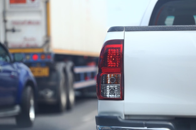 Photo le feu arrière d'une voiture qui freine sur la route et une image floue derrière une autre voiture