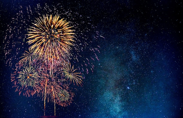 Feu d'artifice avec fond de voie lactée flou