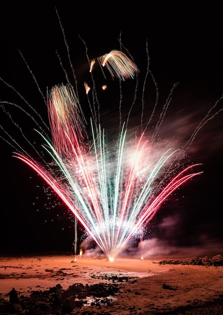 Photo un feu d'artifice sur la plage pendant la nuit