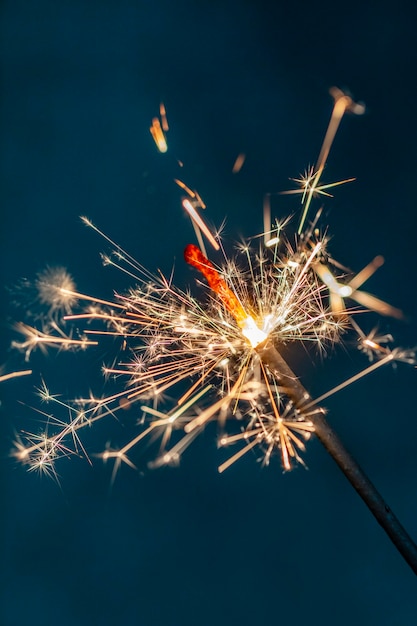 Le feu de Bengale de Noël scintille sur le fond noir.