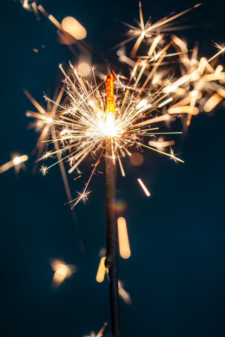Le feu de Bengale de Noël scintille sur le fond noir.