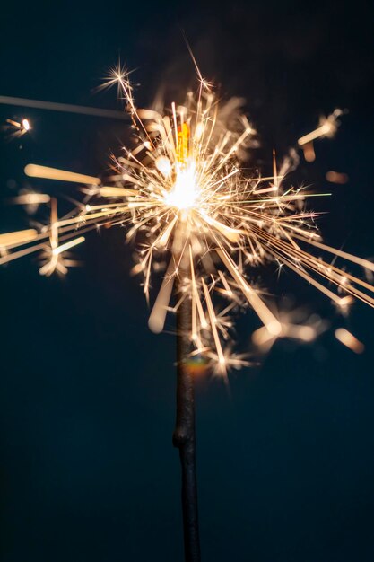 Le feu de Bengale de Noël scintille sur le fond noir.