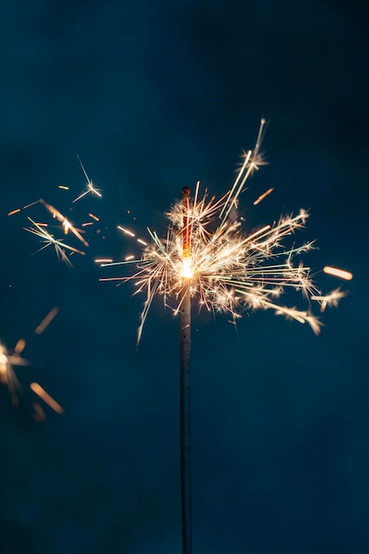 Le feu de Bengale de Noël scintille sur le fond noir.