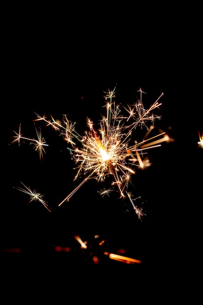 Un feu de Bengale scintille sur le fond noir.