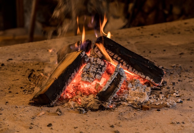 Feu de bois et braises utilisés pour fumer des aliments ou four de boulangerie fait maison