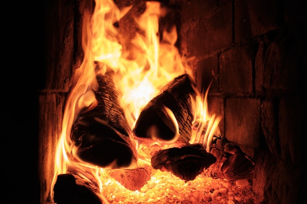 Un Feu Brûle Dans Un Poêle De Village En Briques. Flammes, charbons ardents et bûches