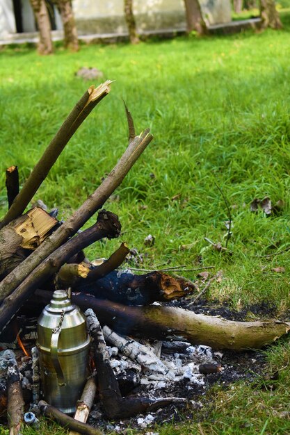 Un feu de camp avec un pot en métal dessus