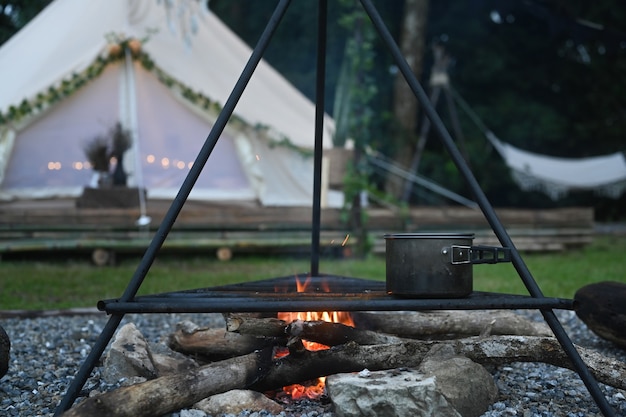 Feu de camp près de la tente de camping dans la forêt.