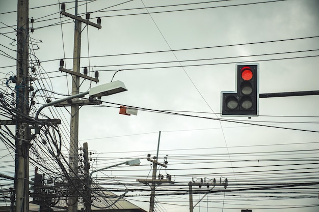 Photo feu de circulation aux intersections montrant un feu rouge avec des câbles électriques et des fils de communication