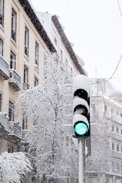 Feu de circulation enneigé sur vert un jour d'hiver enneigé