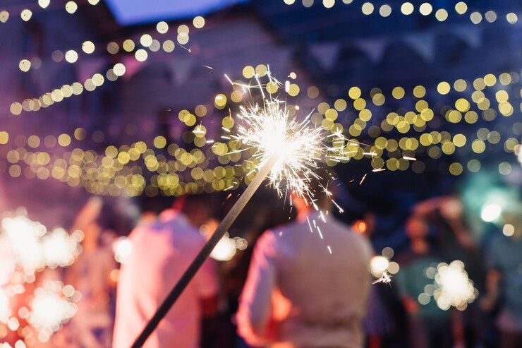 Photo feu du bengale sur le fond de la fête, des gens dansants et des lumières colorées