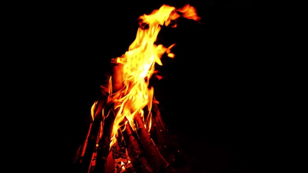 Feu de joie allumé la nuit avec les lumières de la ville nocturne reflétées dans le lac.