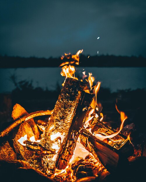 Photo feu de joie par une structure en bois contre le ciel la nuit