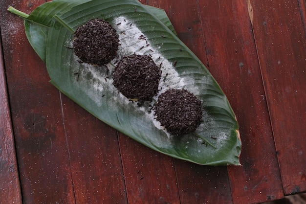 Une feuille de bananier avec des truffes noires dessus