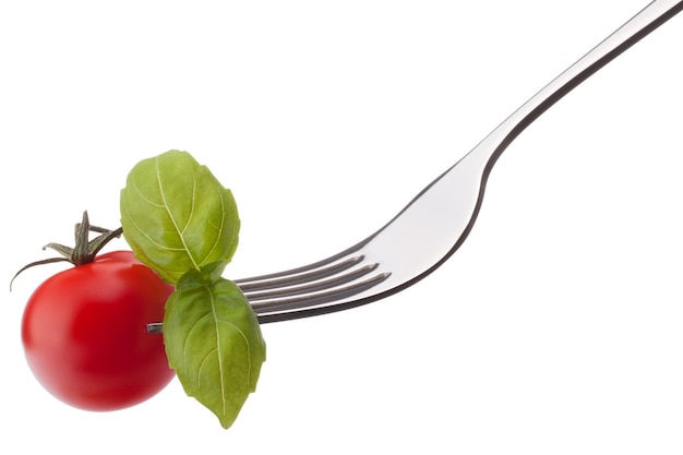 Feuille de basilic et tomate cerise sur fourche isolé sur fond blanc dentelle