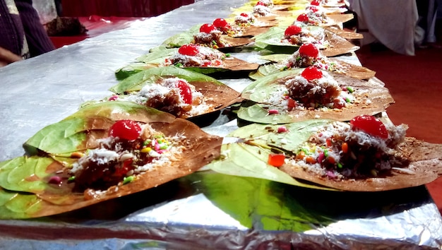 Feuille de bétel ou meetha banarasi paan garni de cerises et de toutes sortes d'ingrédients indiens banarasi ou masala à vendre.