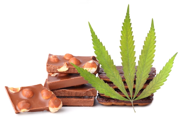Feuille de chanvre avec des morceaux de chocolat avec des noix contenant du cannabis CBD