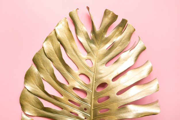 Feuille de palmier tropical doré Monstera sur rose pastel de luxe.