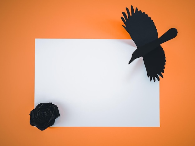 Feuille de papier blanche avec corbeau noir sur orange